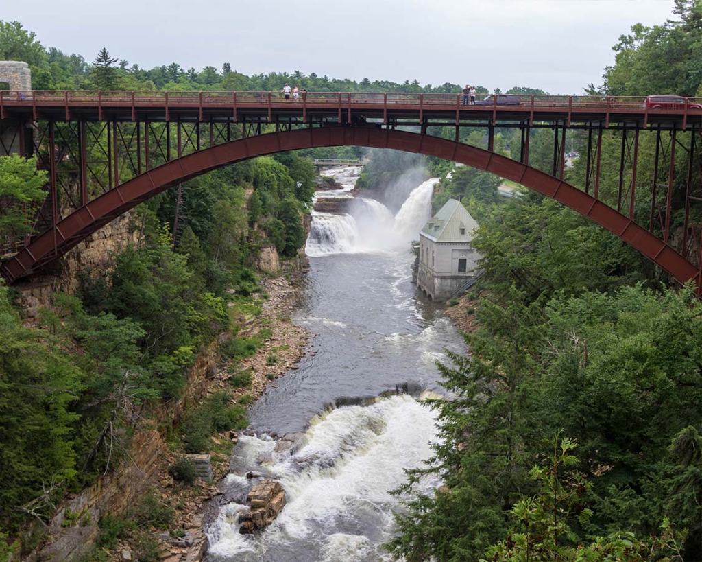 Picture shows a bridge over a large chasm with rapids flowing underneath.